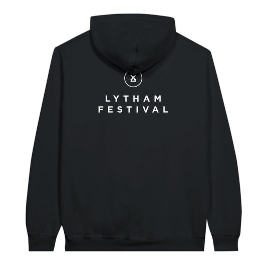 The Lytham Festival Pullover Hoodie by Lytham Festival is a black fleece knit with bold white LYTHAM FESTIVAL lettering on the back, a small circular tent logo below the hood, and a double-lined hood for extra warmth.